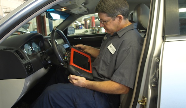 Photo of technician using automotive diagnostic computer