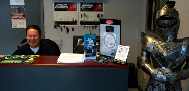 Photo of James at the front desk next to suit of armor