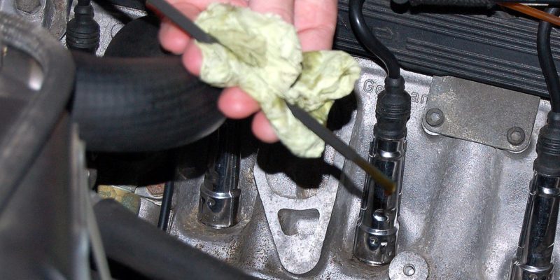 Photo of mechanic checking engine oil with a dipstick